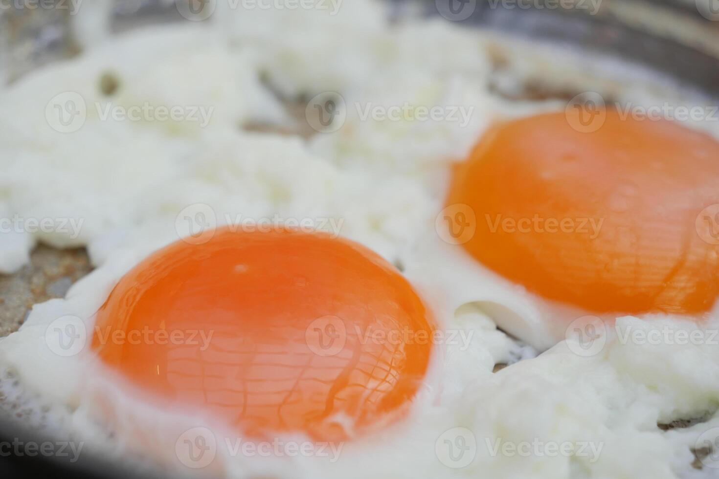 A CloseUp Image of Freshly Fried Eggs Cooked in a Pan for You to Enjoy and Indulge photo