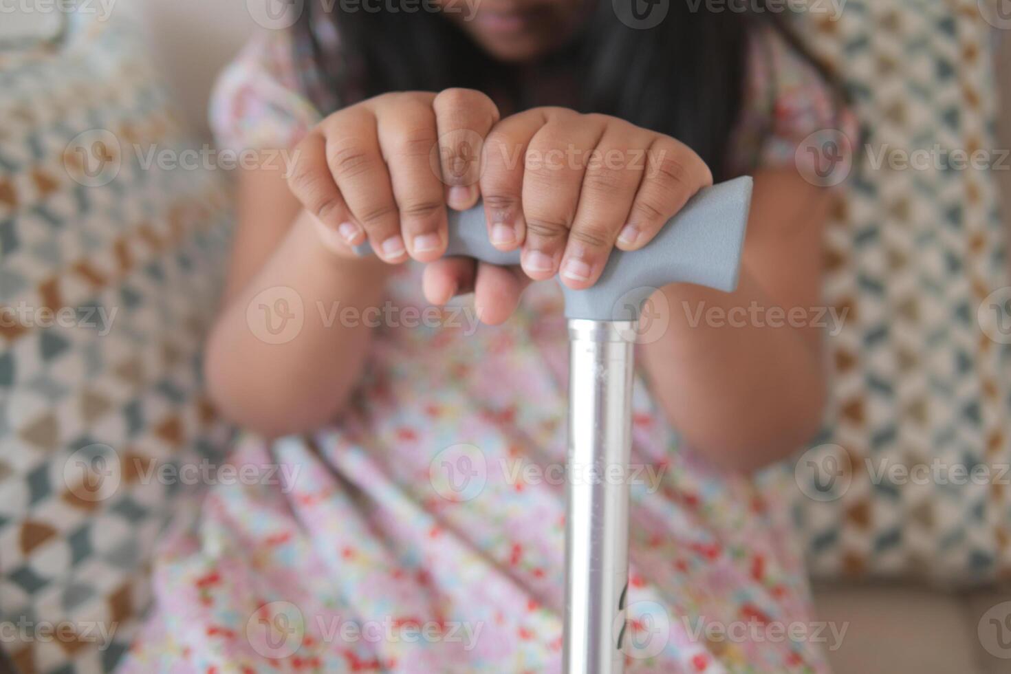 Close-Up of Child's Hands Gripping a Walking Aid photo