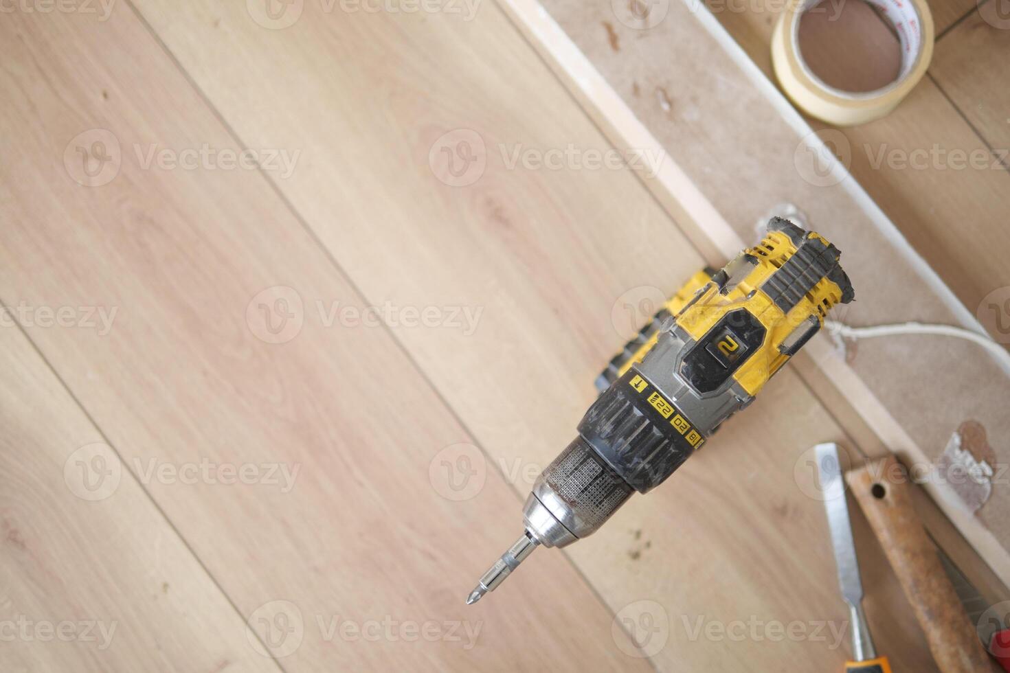 Using a Power Drill on a Wooden Floor for a Home Improvement Project and Renovation photo