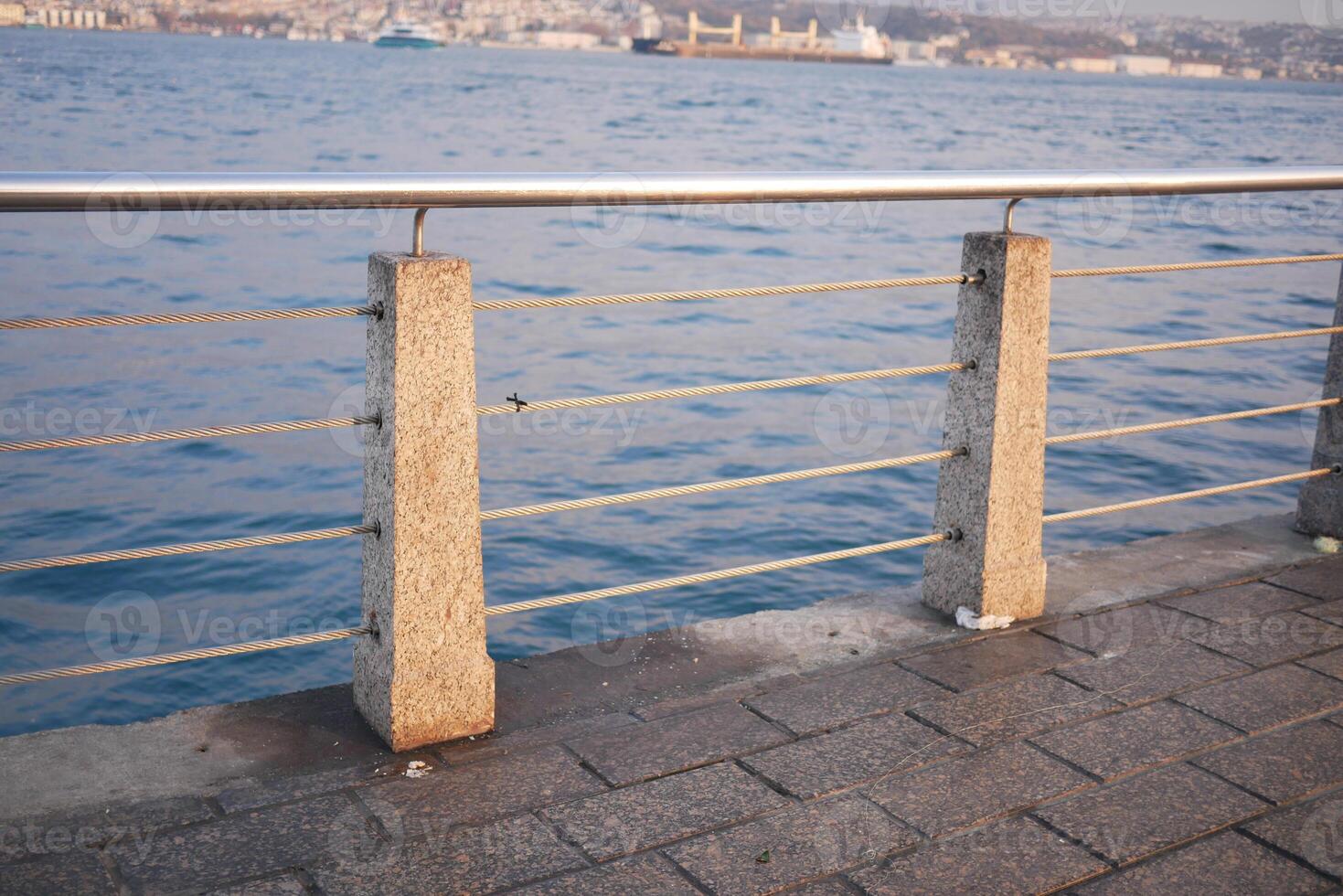 Stunning Seaside Promenade with Sturdy Concrete Railings by the Calm and Peaceful Waters photo