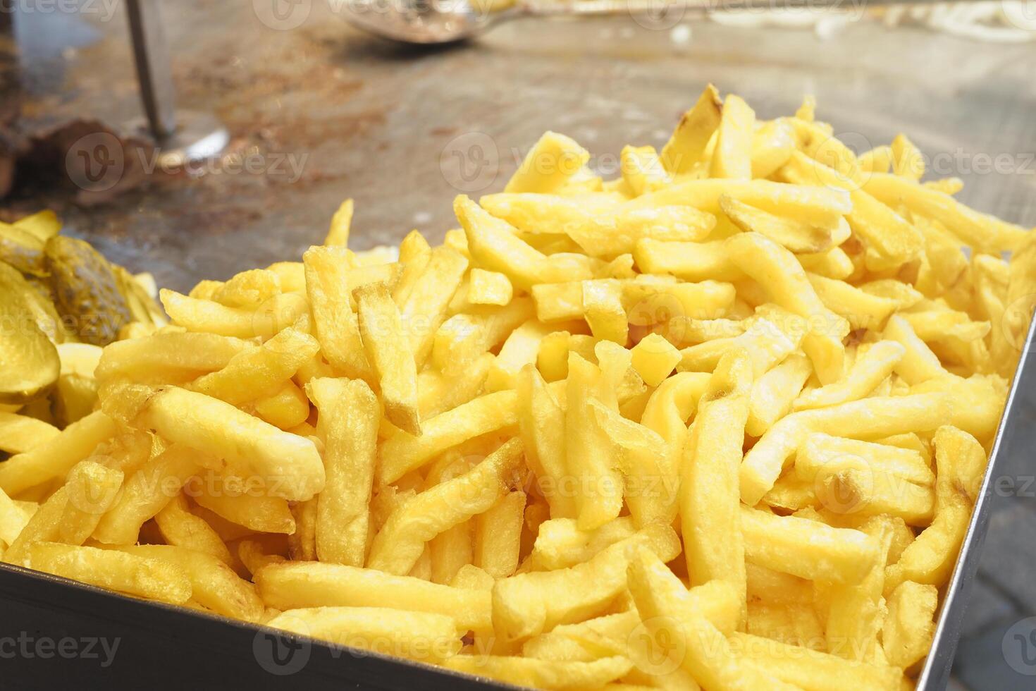 A Pile of Golden Crispy French Fries Located in a Bustling Fast Food Setting Enjoying Popularity photo