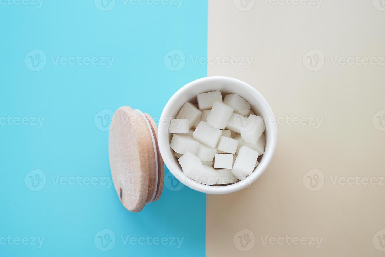 Sugar cubes artfully arranged in a white container with a vibrant, colorful background photo