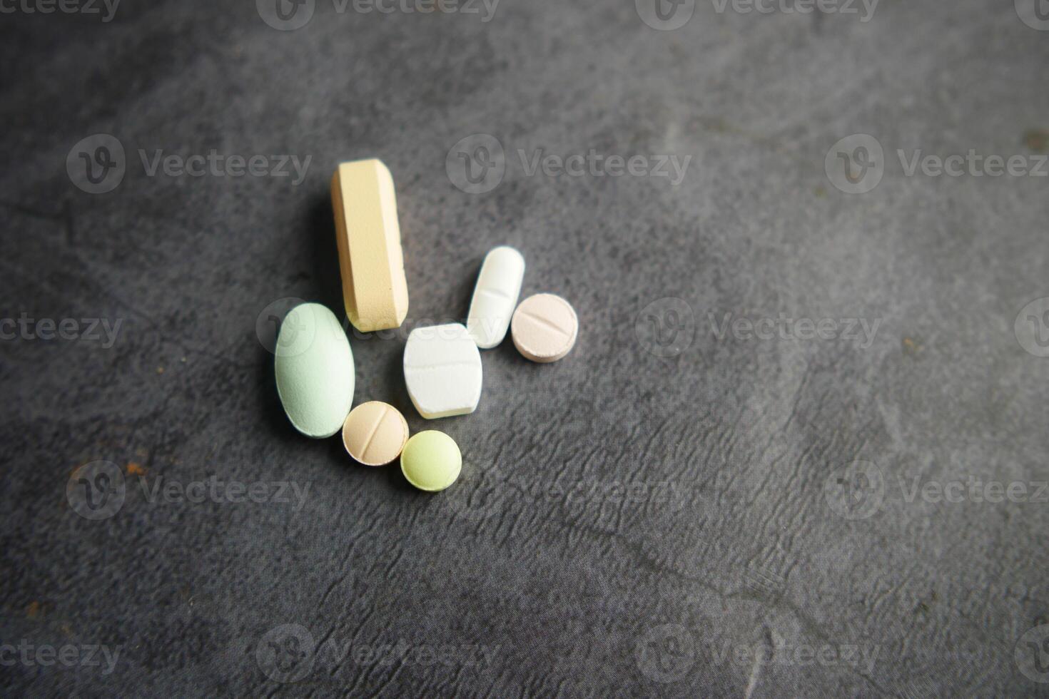 A variety of Assorted Pills and Tablets beautifully displayed on a Dark Background photo