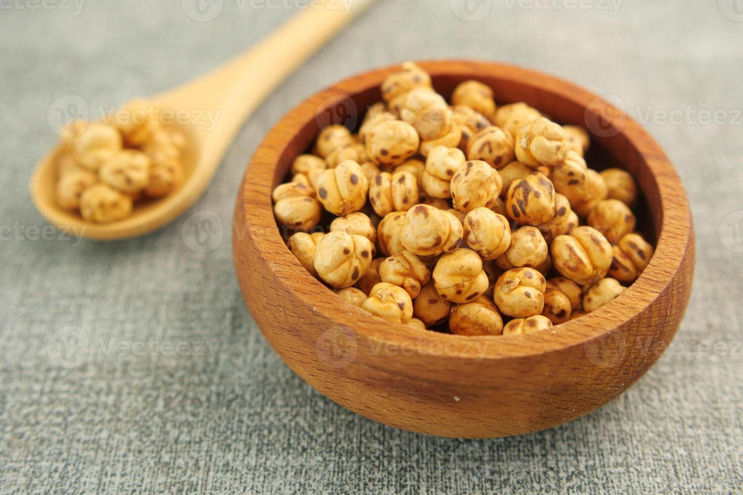 Wooden Bowl Filled with Roasted Chickpeas on a Rustic Table photo