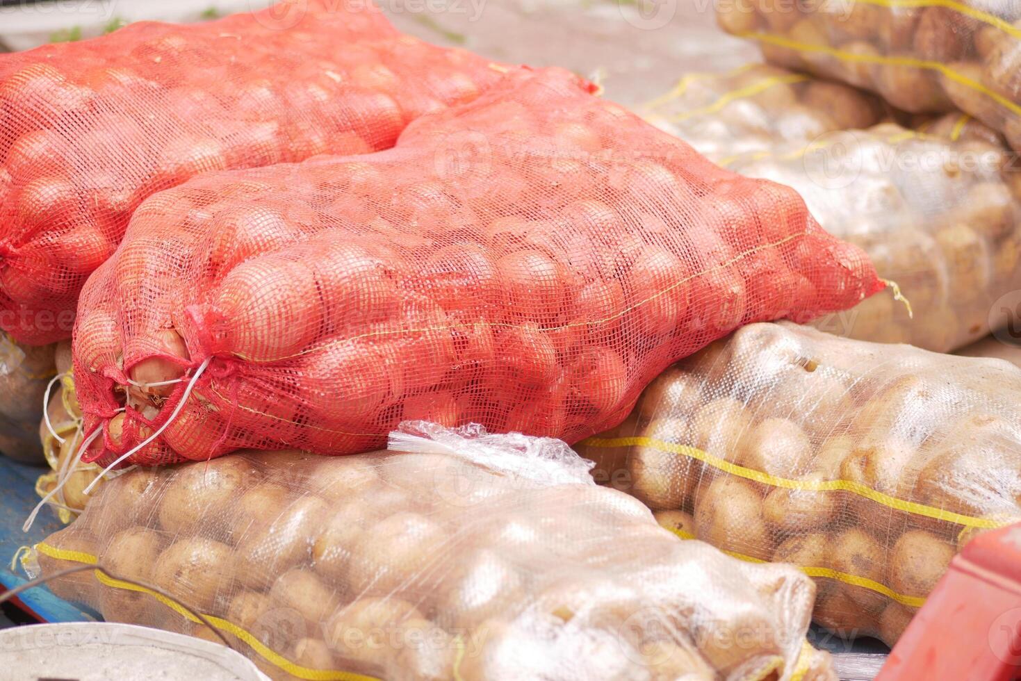 Large sacks of fresh, nutritious potatoes are prominently displayed at a market stall photo