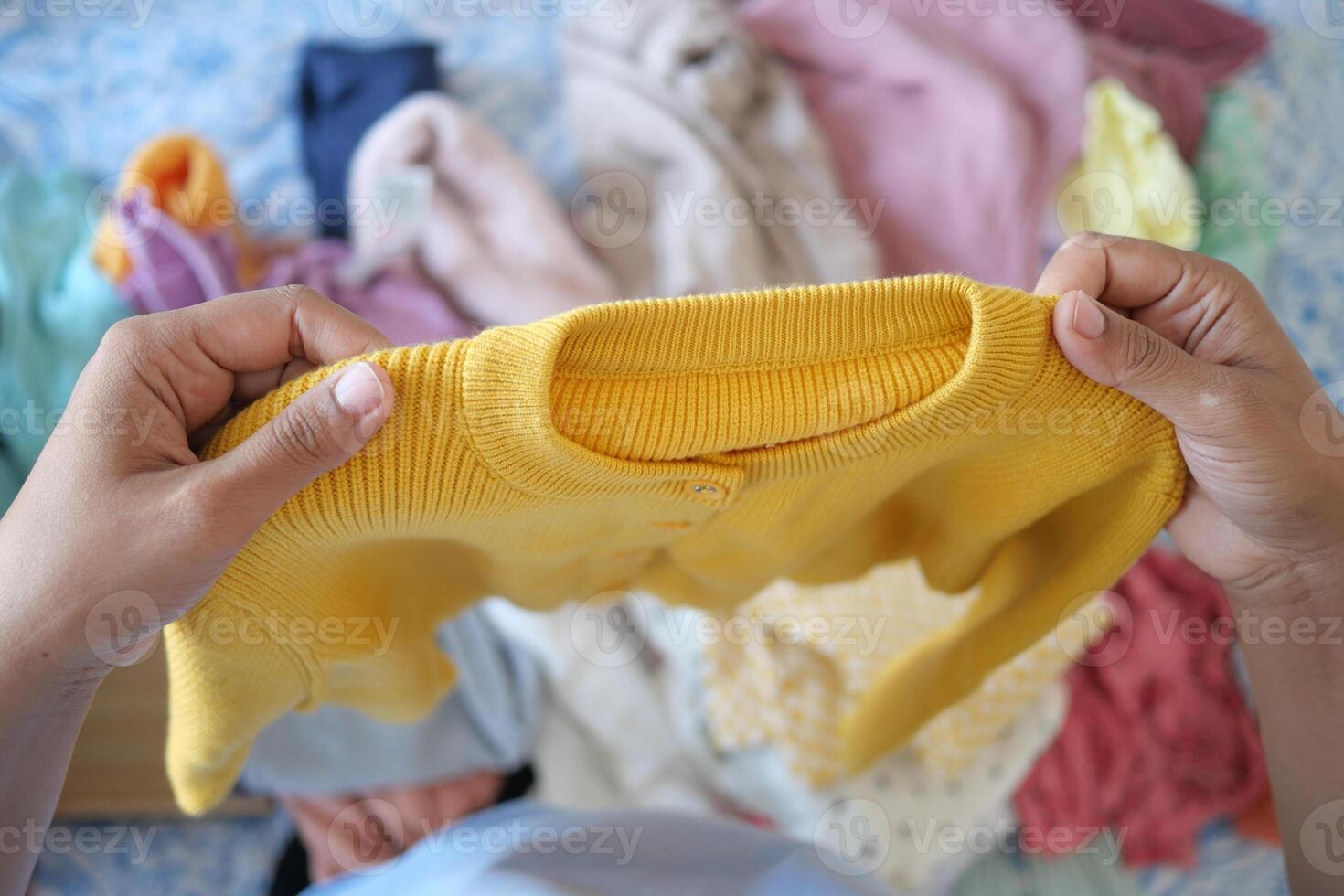 Organizing and Sorting Colorful Clothing A CloseUp Observational Look at a Yellow Sweater photo