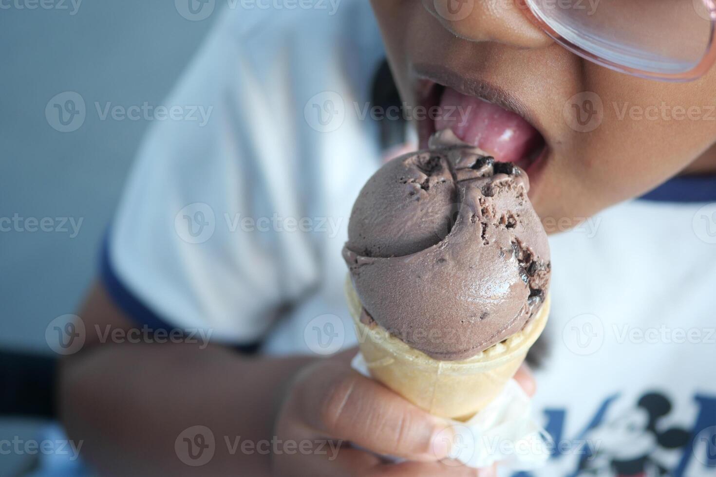 child happily eating an ice cream bar, exuding joy and enjoyment photo