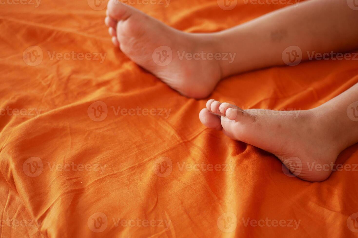 Bare feet of a child on a bed photo