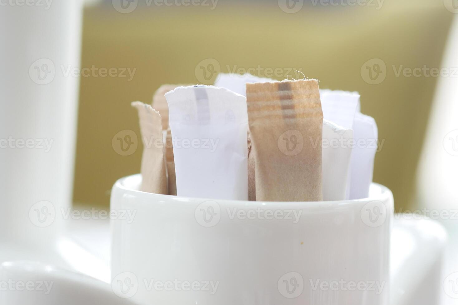 white sugar in a paper packet on table photo