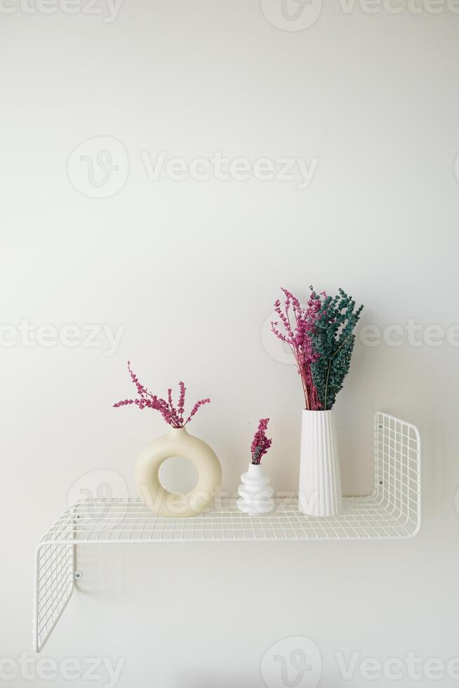 Stylish and Elegant Shelf Decor Featuring Colorful Dried Flowers Arranged in Minimalist Vases photo