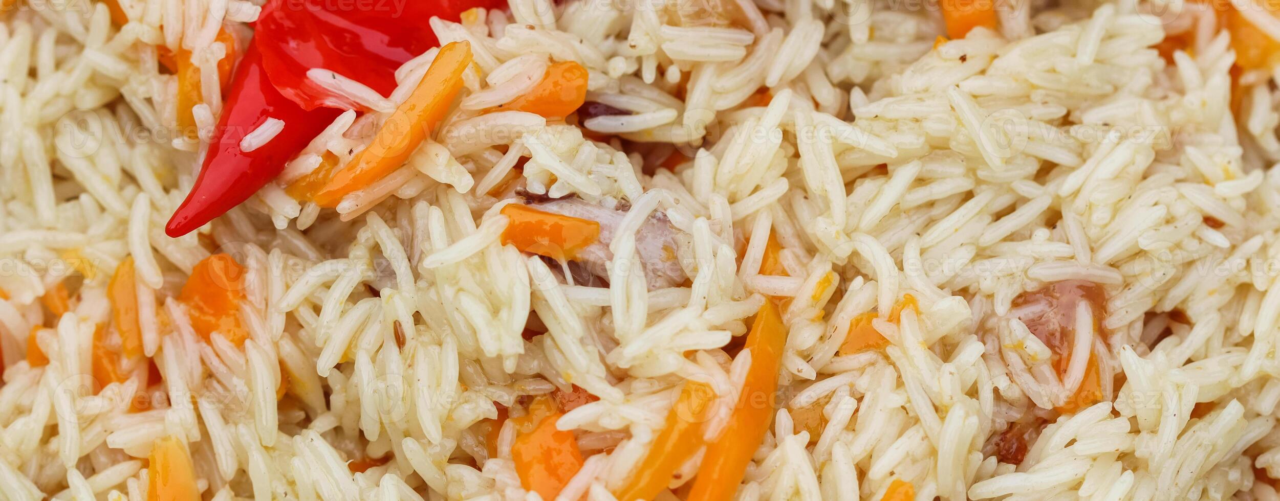 Cooking rice pilaf in a large cast-iron pot on fire photo