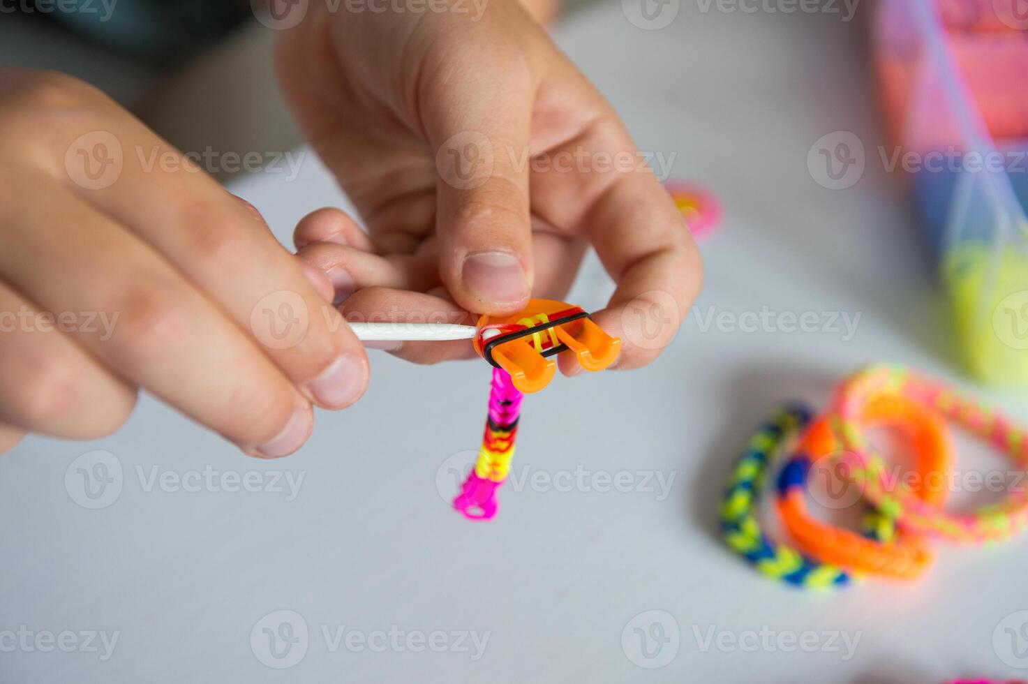 Child Crafting Colorful Loom Bracelets at Home photo