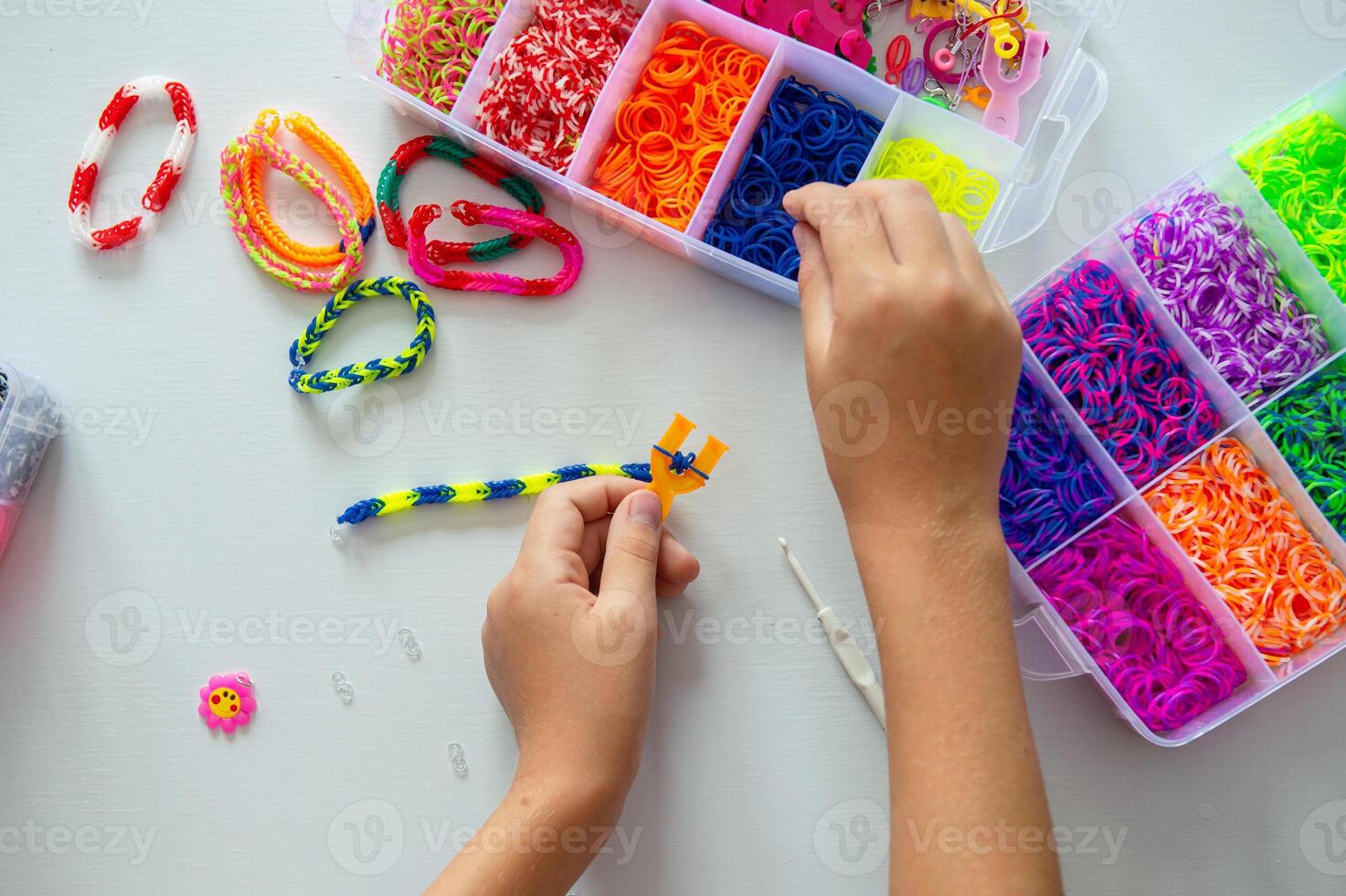 Crafting Colorful Loom Bracelets with Rainbow Bands on White Surface photo