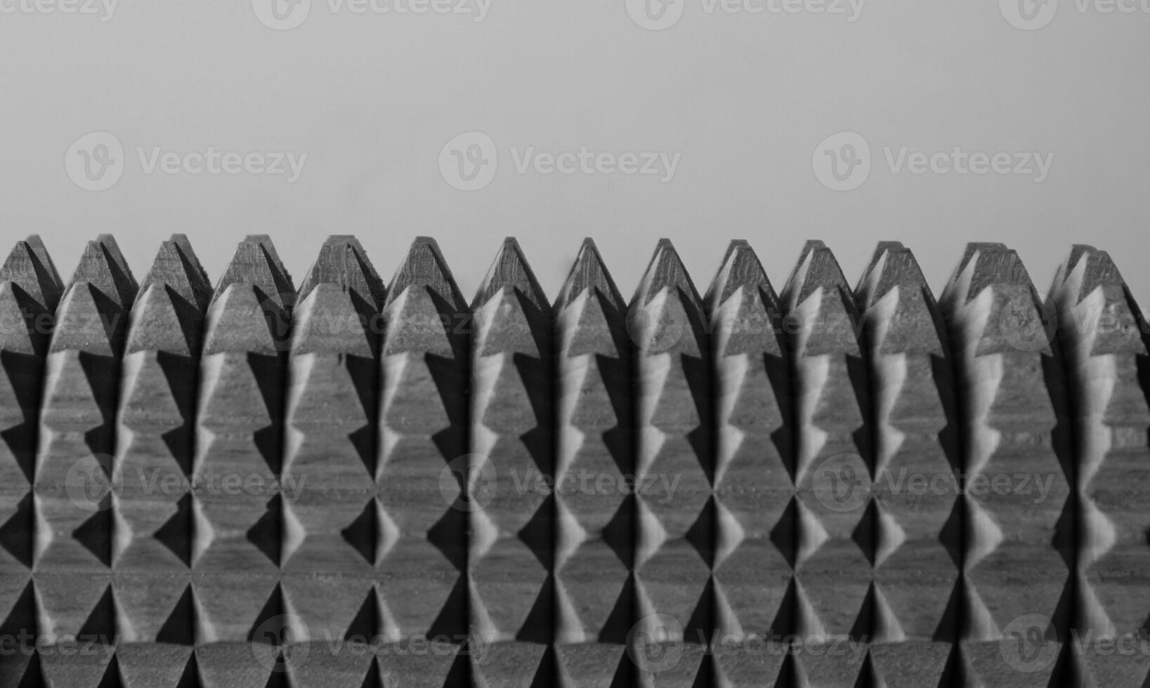 Same geometric spikes on jagged metallic mechanism on white background macro shot stock photo