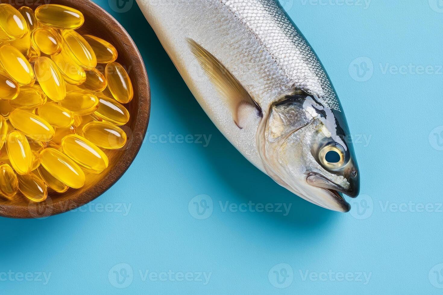 Fresh fish alongside a bowl of golden omega 3 capsules photo