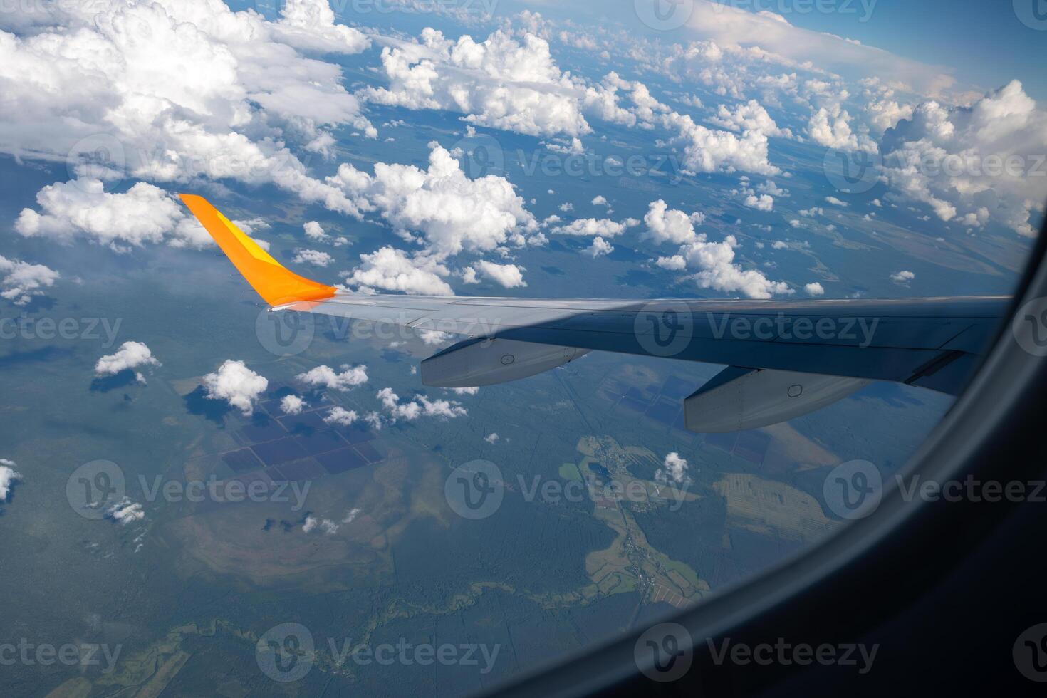 View from airplane window on wing and landscape with clouds on window during flight. photo