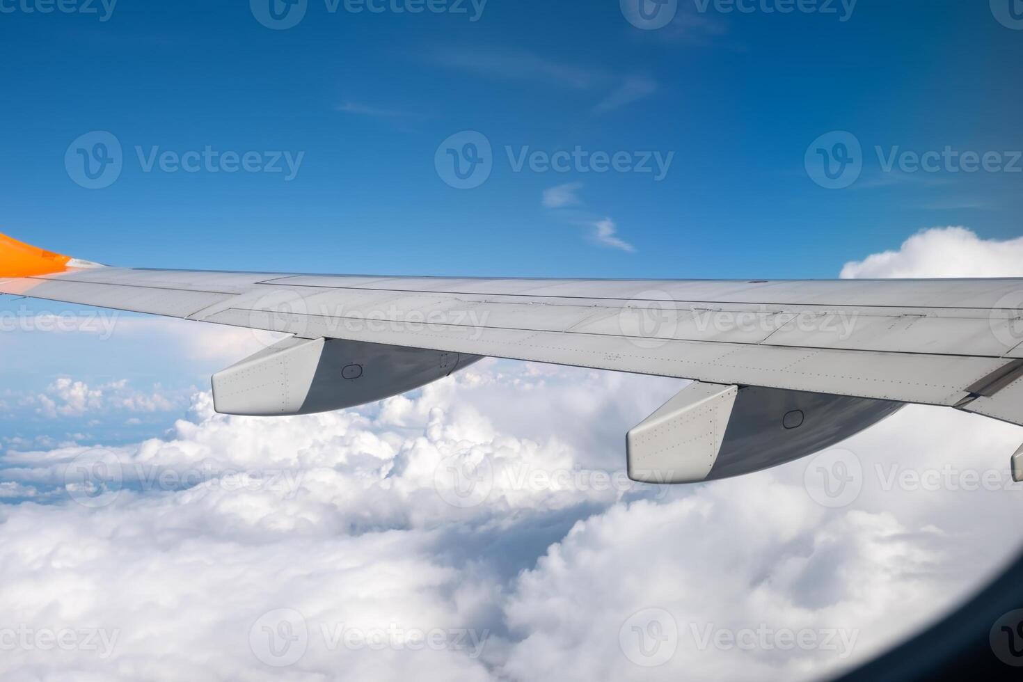 View from airplane window on wing and landscape with clouds on window during flight. photo