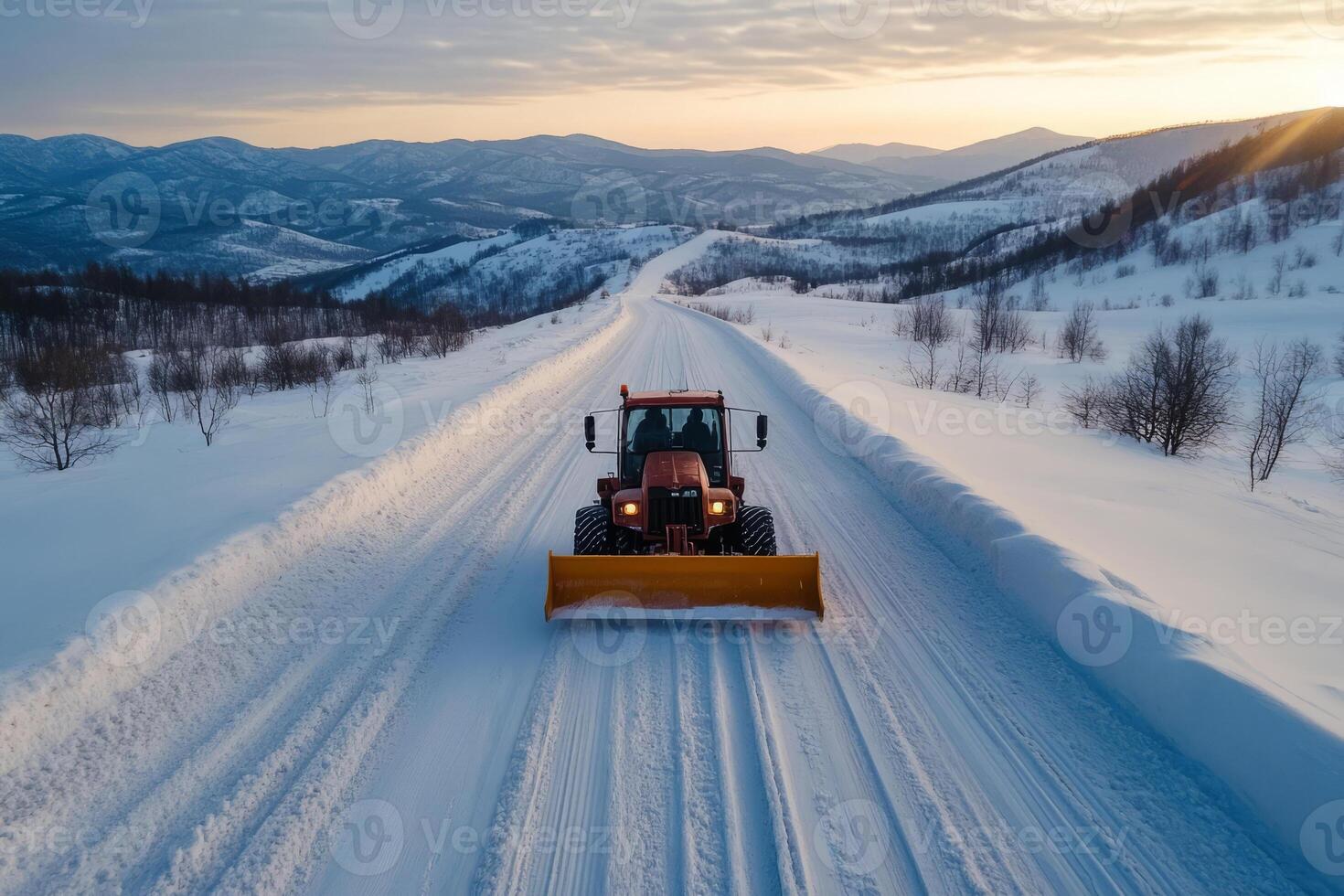 Snowplow truck clearing snow from a road, surrounded by snowy landscapes photo