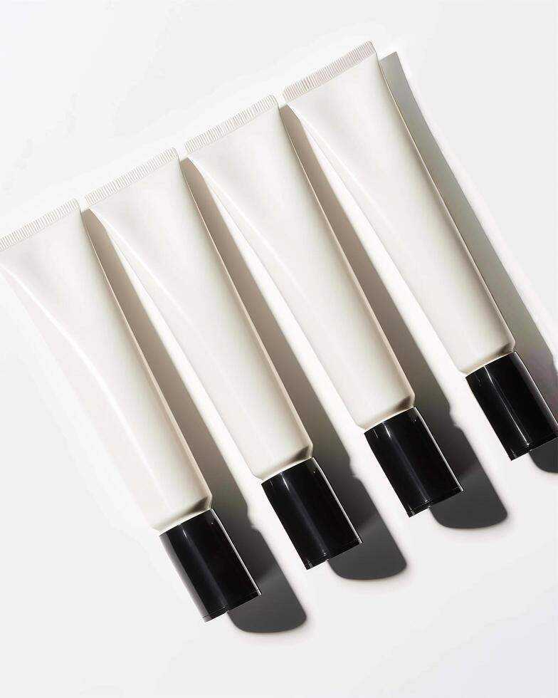 Four tubes of hand cream with black cap on a white surface photo