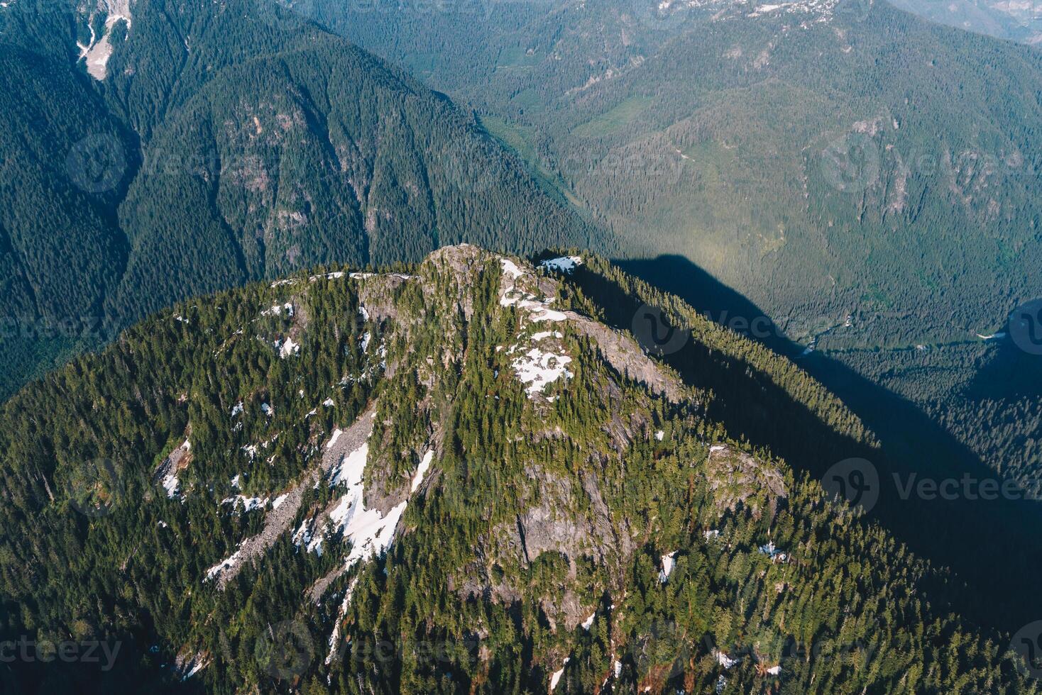 Green mountain peak with traces of snow on the top photo