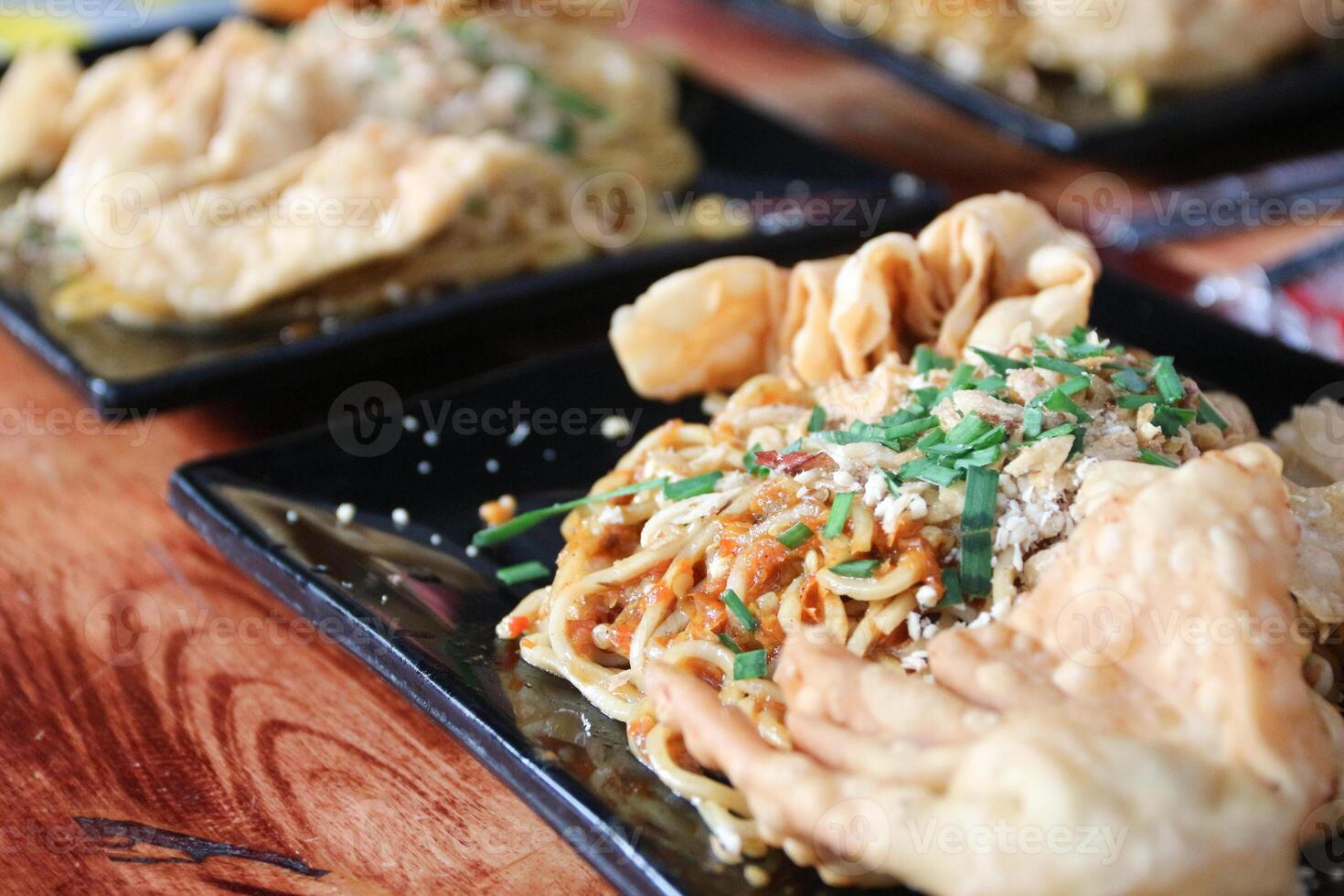 Gacoan noodles are a popular food in Indonesia. Made from noodles served with spicy spices and fried dumplings. photo
