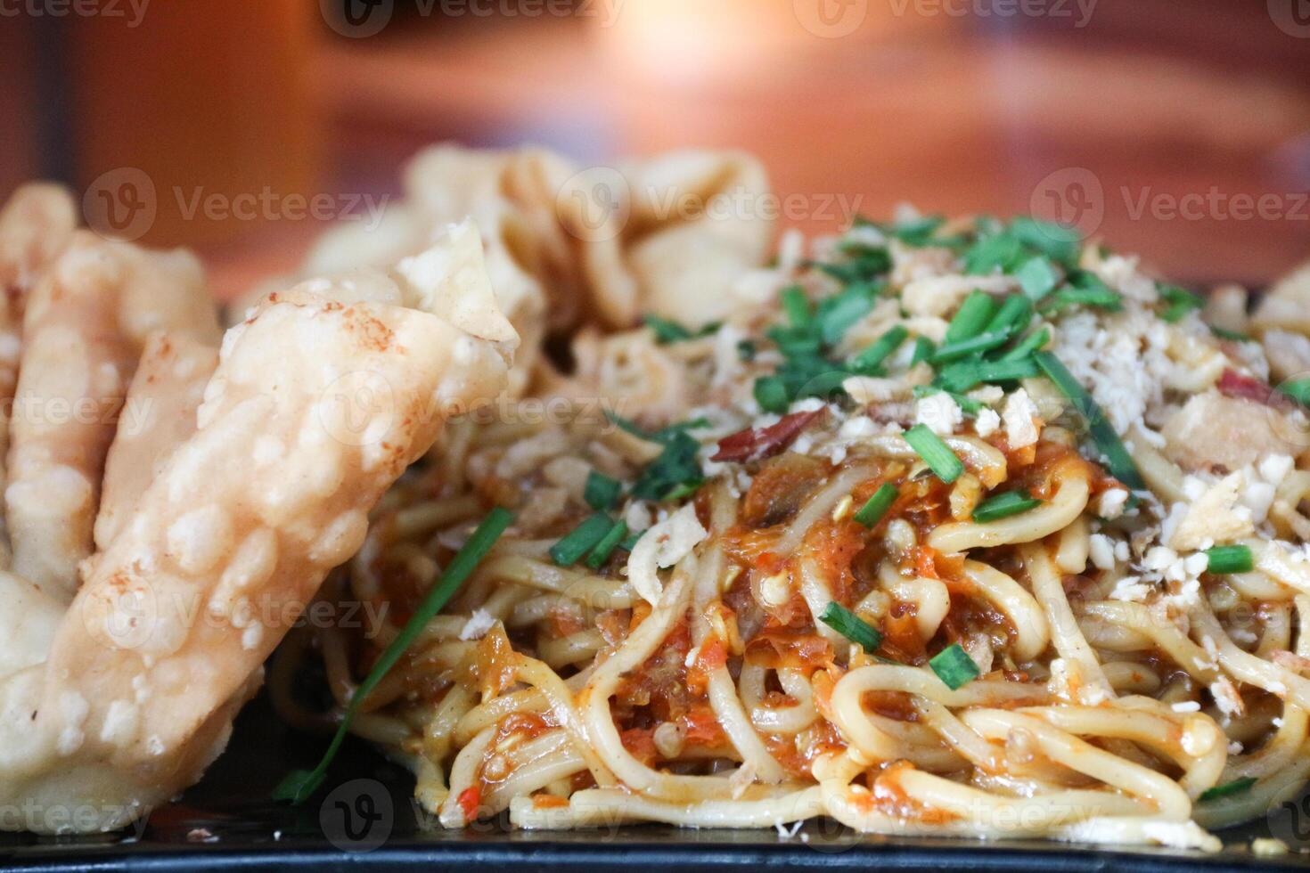 Gacoan noodles are a popular food in Indonesia. Made from noodles served with spicy spices and fried dumplings. photo