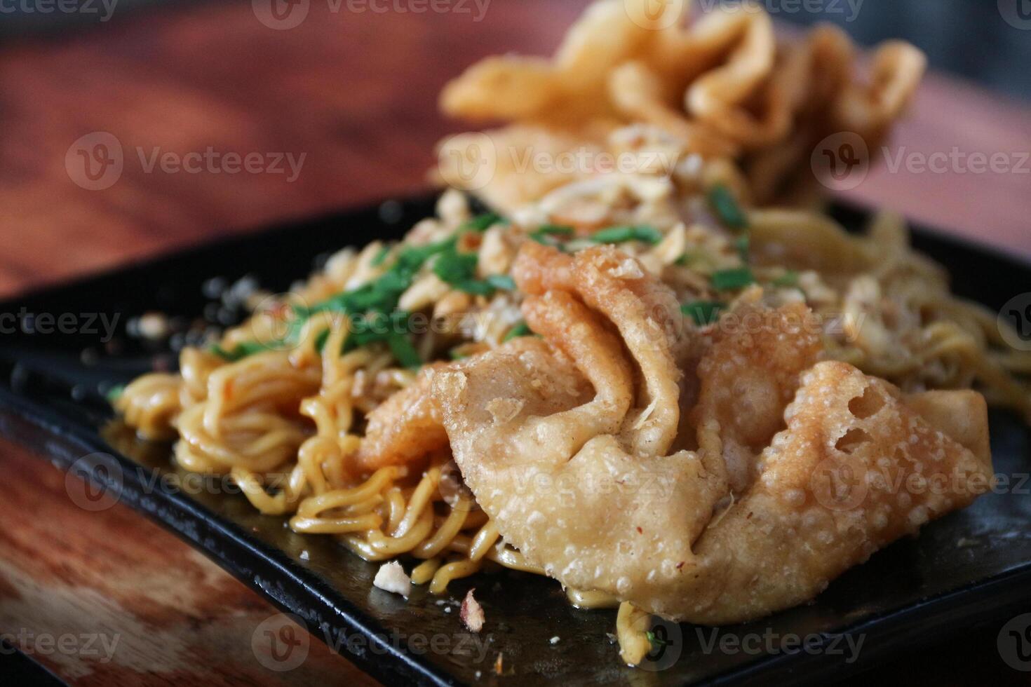 Gacoan noodles are a popular food in Indonesia. Made from noodles served with spicy spices and fried dumplings. photo