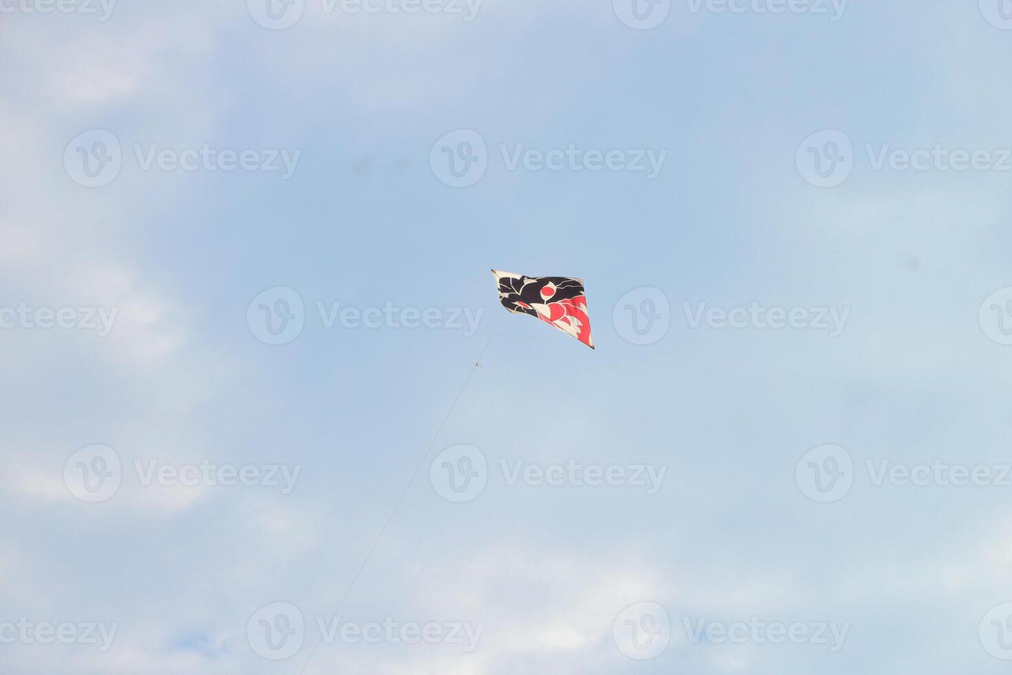 Colored paper kite like rainbow on blue sky background. Kites are flown along the beach. Beautiful colors in the air photo