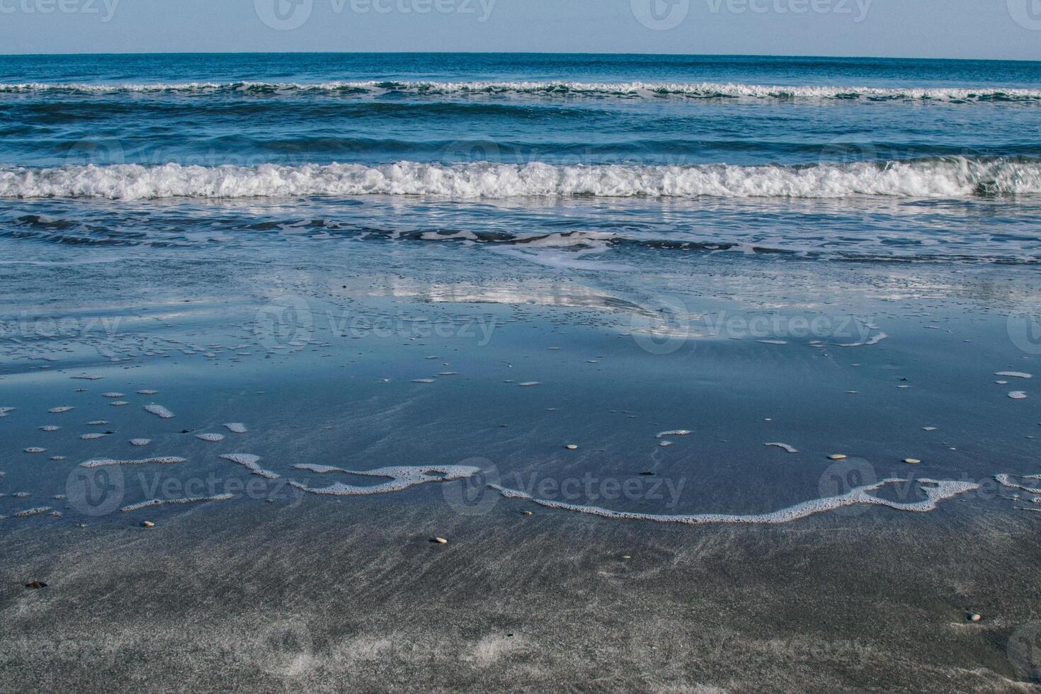clear blue sea washes the shore photo
