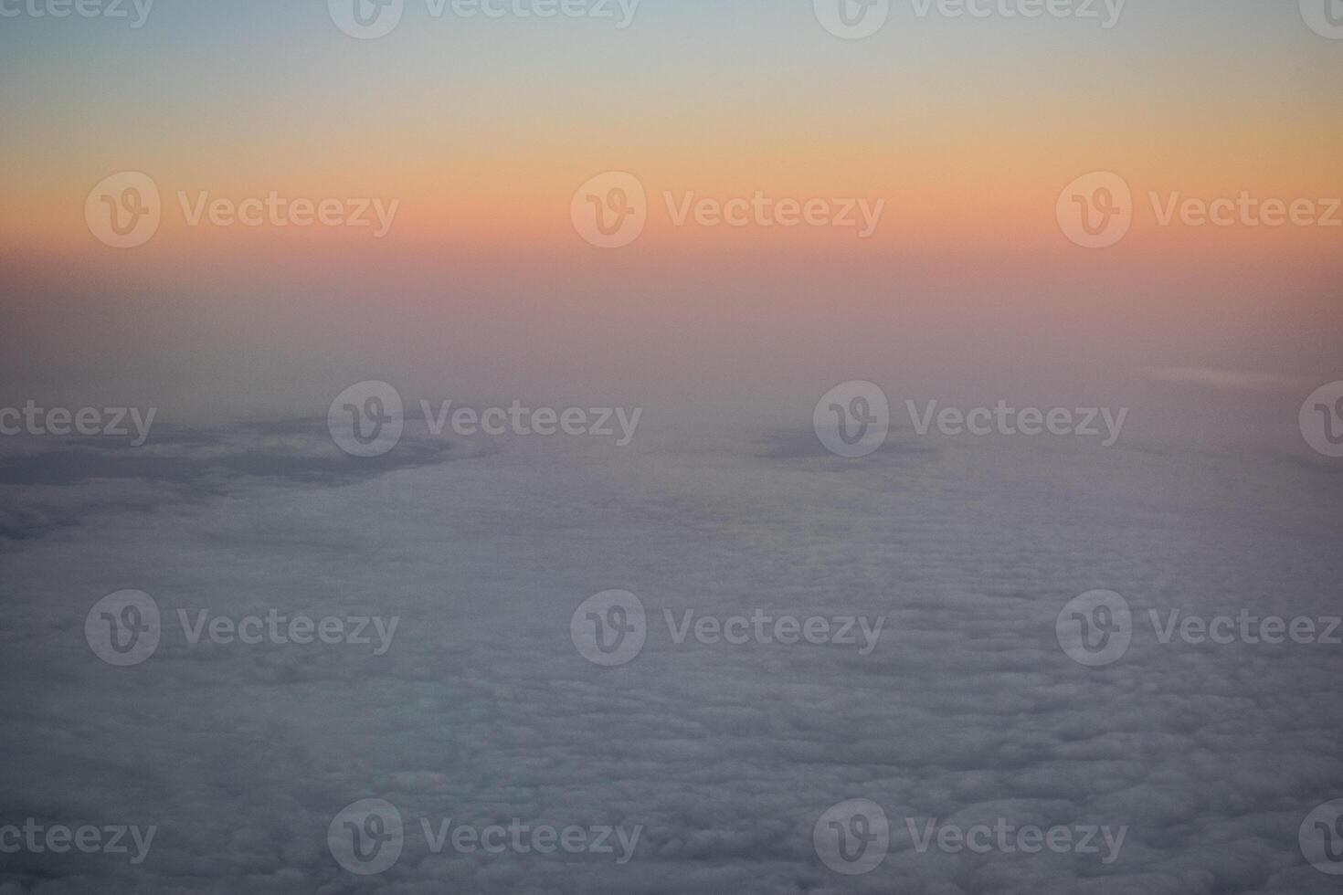 a dawn above the clouds through the porthole photo
