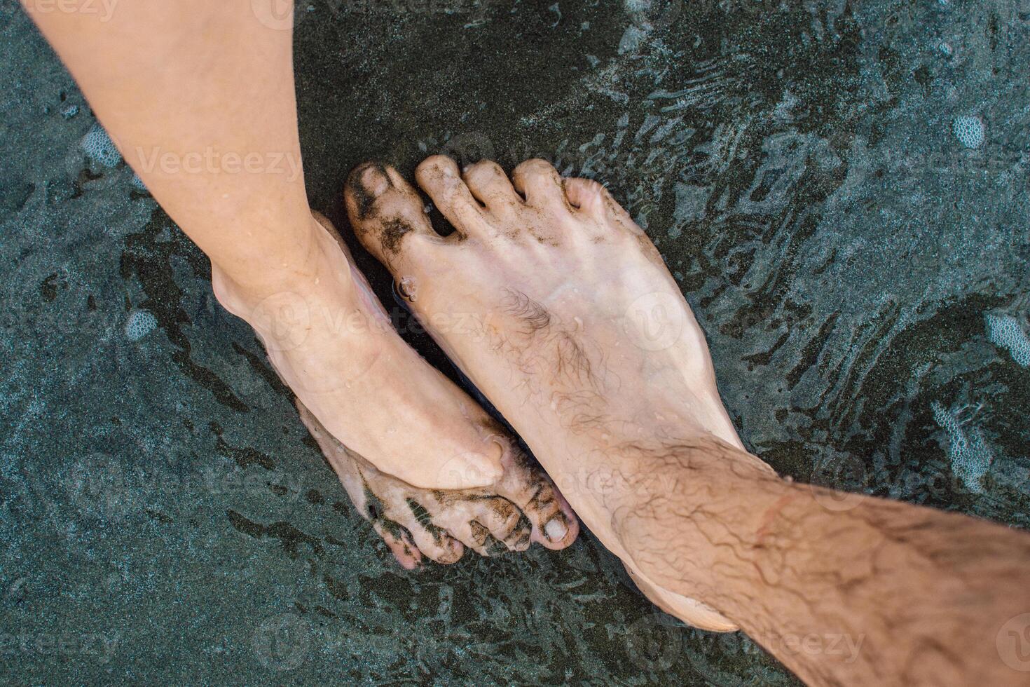 the bare feet of man and woman on the beach photo