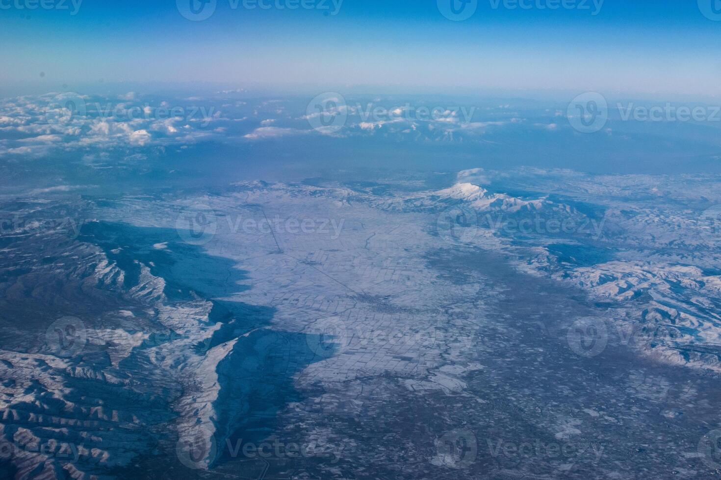 view of mountains covered with snow from an airplane window, Cyprus photo