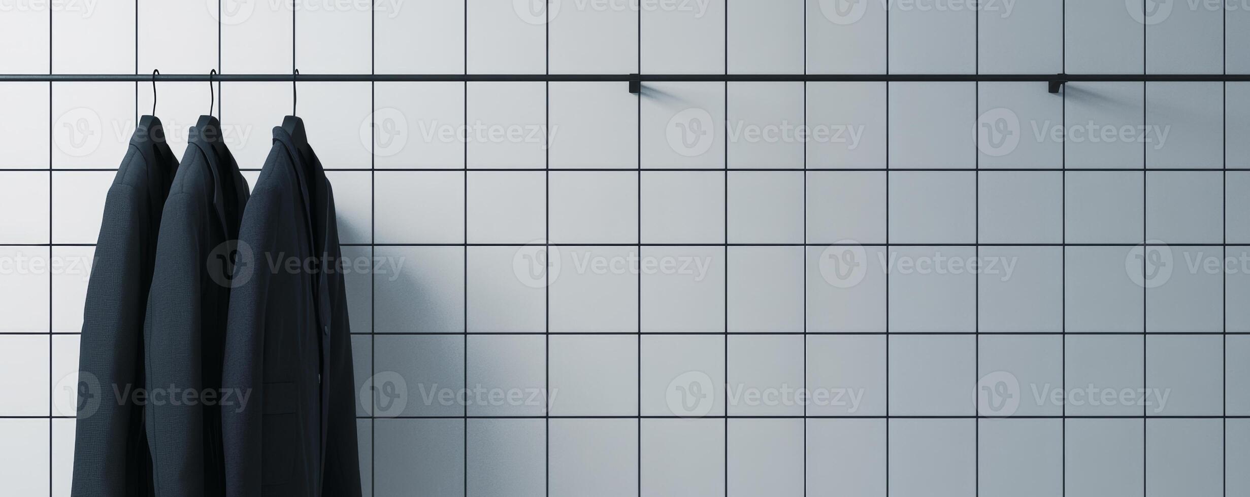 Three black suits hanging on a tiled wall photo