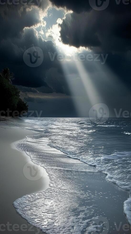 Beach with dramatic clouds and sun rays at dawn photo