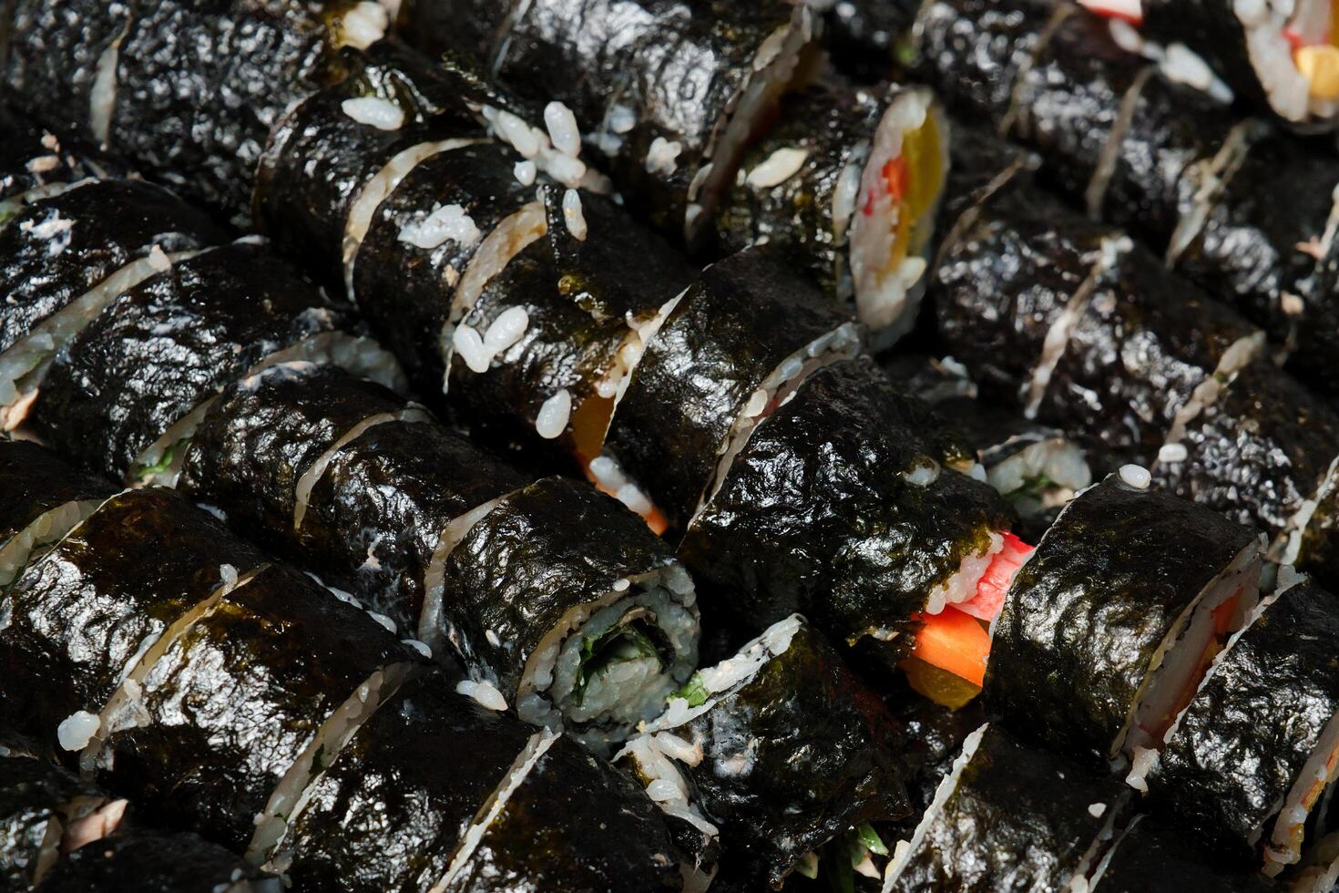 a pile of sushi rolls with different toppings photo