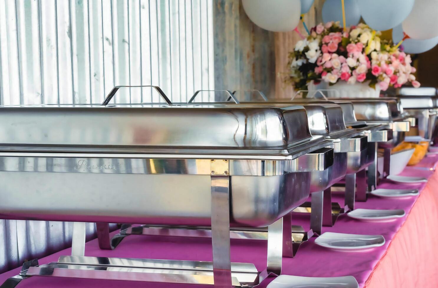 a buffet table with silver chafers and plates photo
