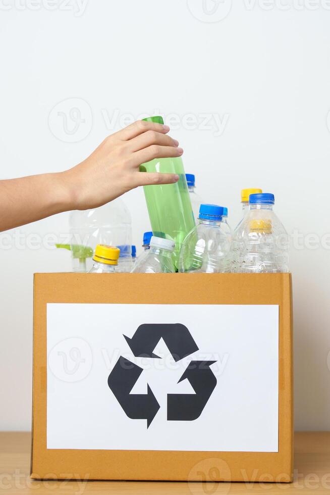Volunteer keep plastic bottle into paper box at home or office. Hand Sorting Recycle garbage. Ecology, Environmental, pollution, Dispose recycling, waste management and trash Separation concept photo