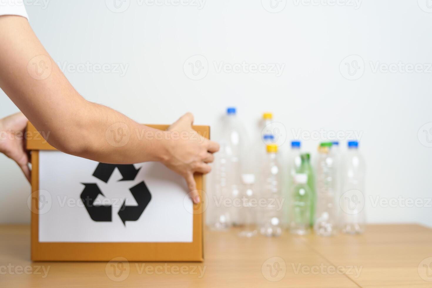 Volunteer keep plastic bottle into paper box at home or office. Hand Sorting Recycle garbage. Ecology, Environmental, pollution, Dispose recycling, waste management and trash Separation concept photo