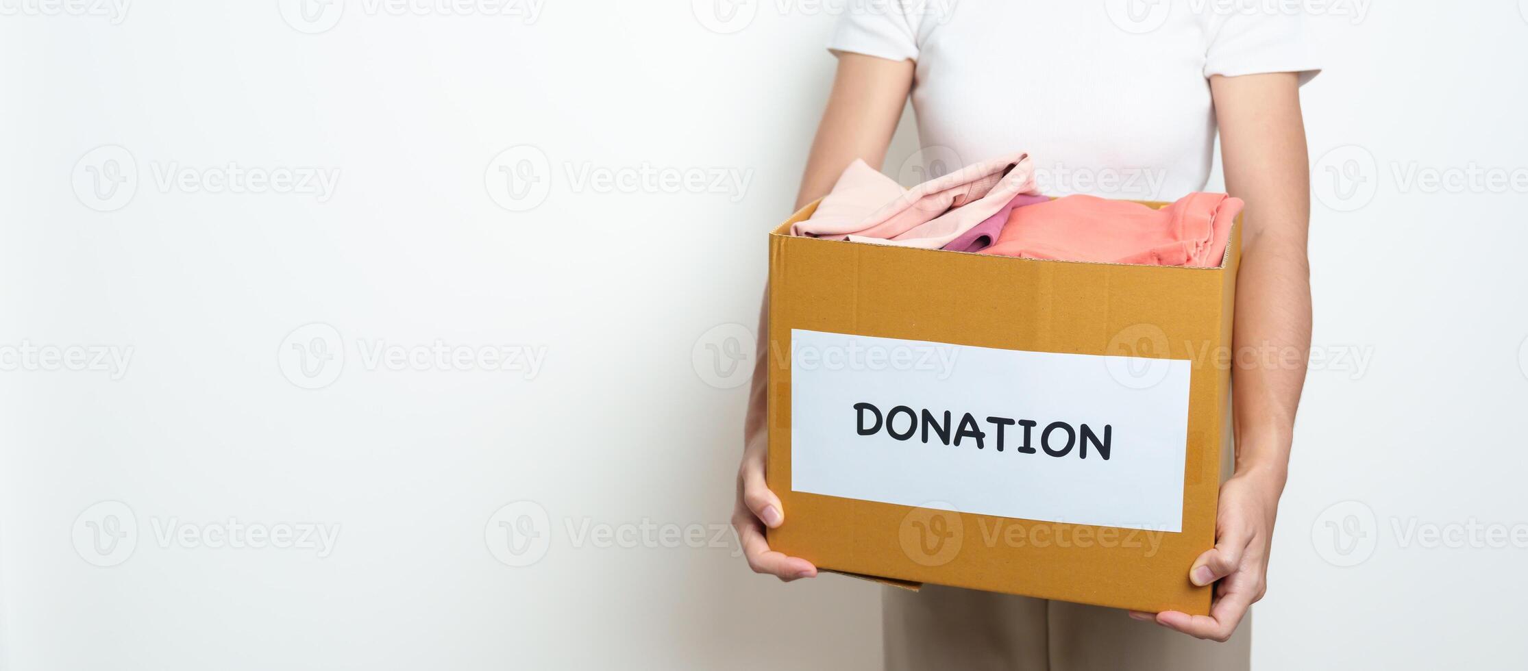 Donation, Charity, Volunteer, Giving and Delivery Concept. People donate Clothes into Donation box at home or office for support and help poor, refugee and homeless people. Copy space for text photo