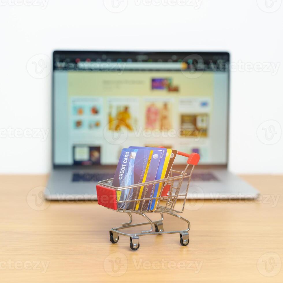 Shopping cart with Credit Cart and laptop computer with marketplace website. Online Shopping, technology, ecommerce, SEO, Search Engine Optimization, Advertising, keyword and online payment concept photo