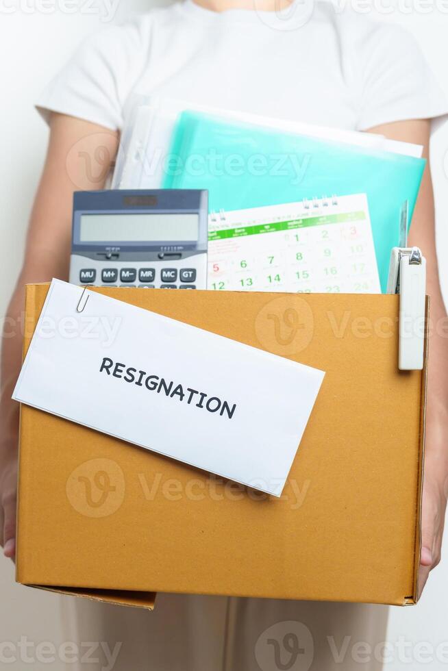Resignation, Layoff, Unemployment, Dismiss, Job quit, Jobless and Farewell concept. Businesswoman holding letter of Resign contract with documents cardboard box at office photo