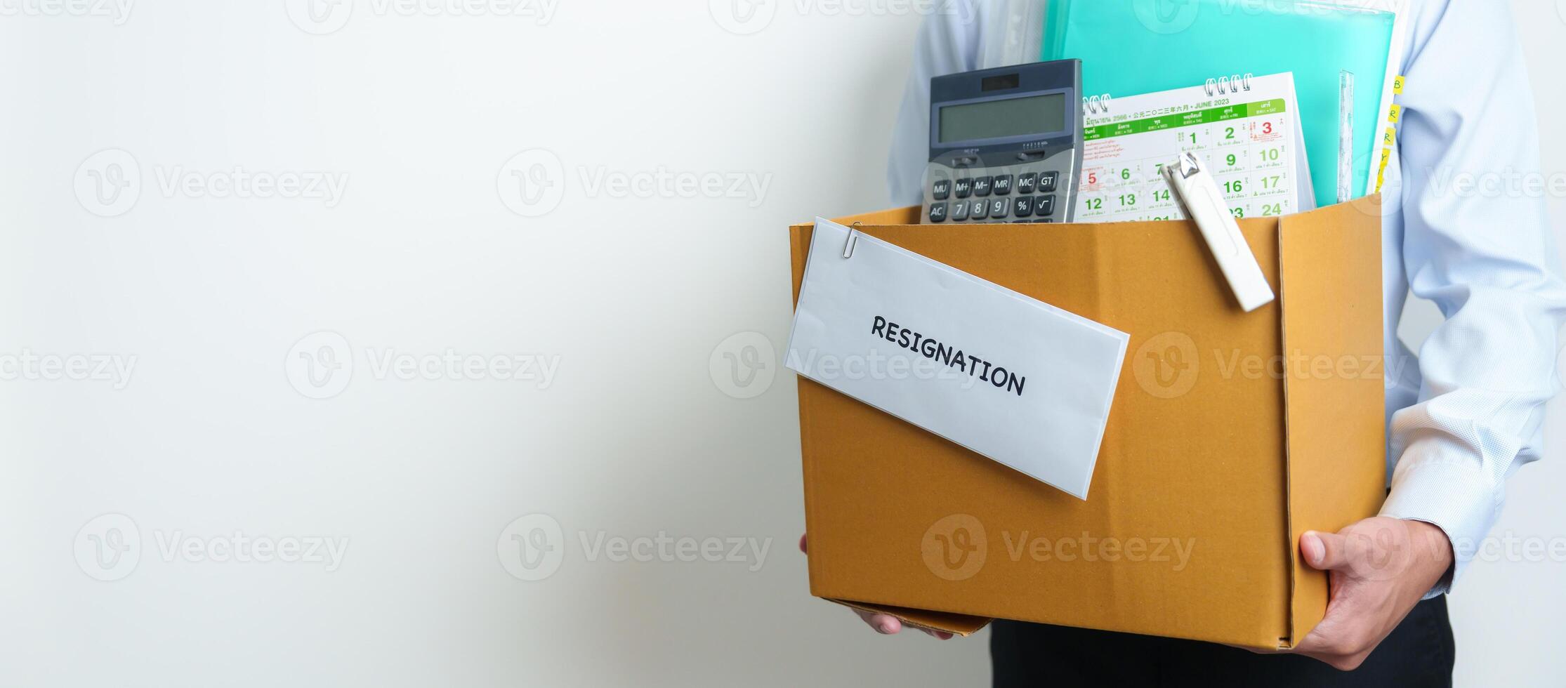 Resignation, Layoff, Unemployment, Dismiss, Job quit, Jobless and Farewell concept. Businessman holding letter of Resign contract with documents cardboard box at office photo