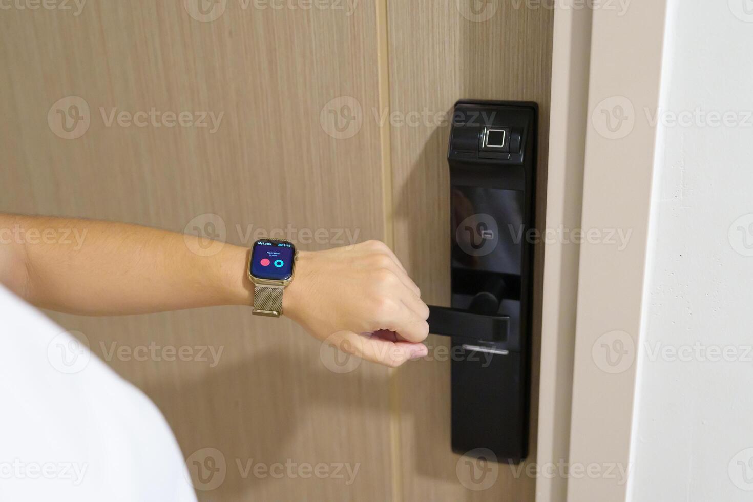 Hand using smartwatch for open digital door lock at home or apartment. NFC Technology, Fingerprint scan, keycard, PIN number, smartphone, electrical and contactless lifestyle concepts photo