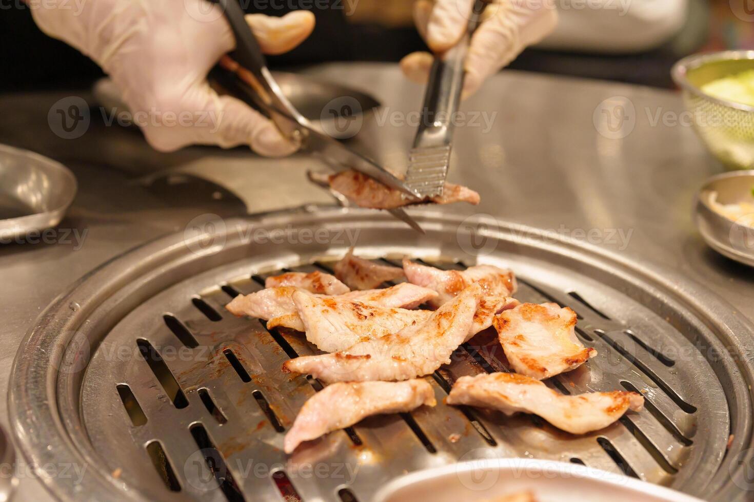 Chef Grilling meat pork on stove serve in restaurant. Korean food and BBQ traditional style photo