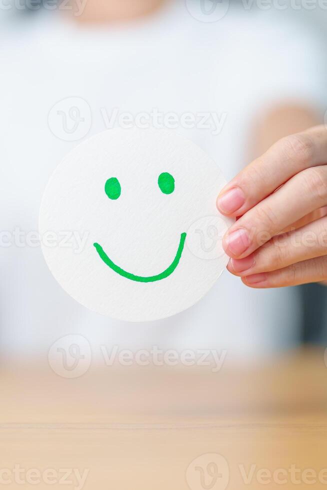 Woman show Happy Smile face paper, Mental health Assessment, Psychology, Health Wellness, Feedback, Customer Review, Experience, Satisfaction Survey, Positive Thinking and World Mental Health day photo