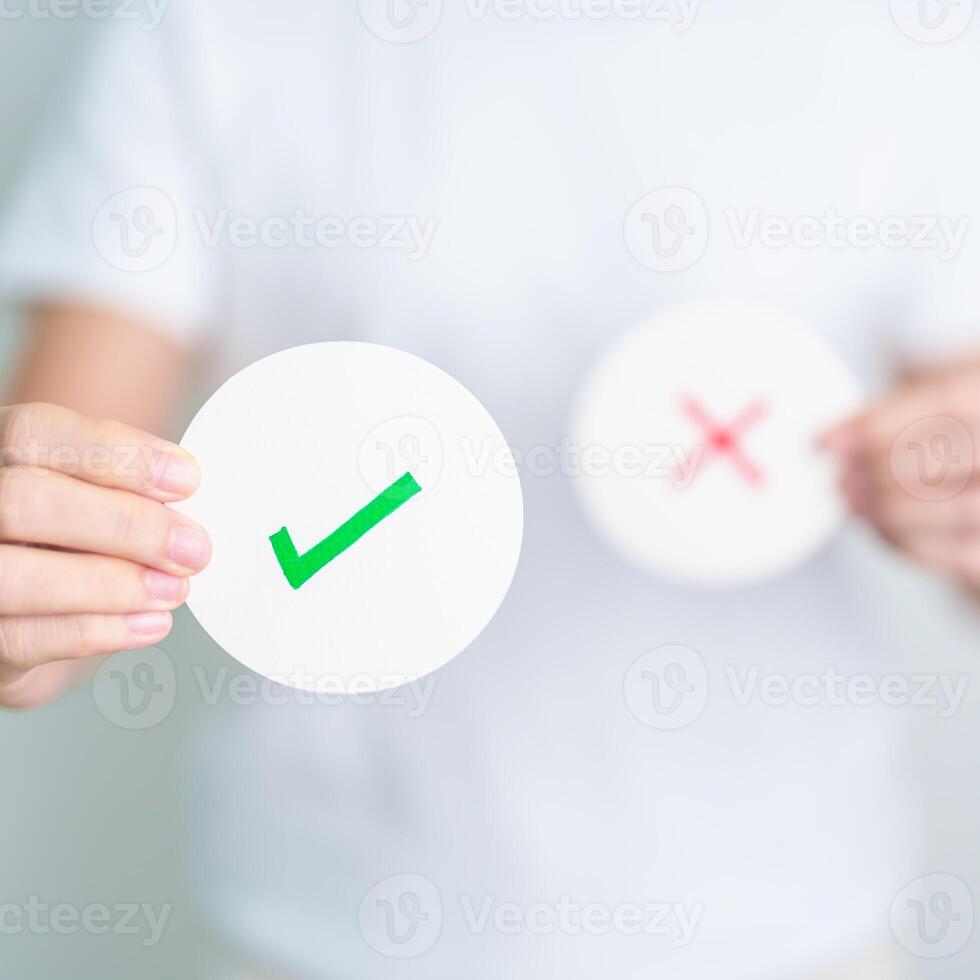 Woman show Right symbol paper. True and false, accept and rejected, evaluation, Vote, Poll, Yes or No and Survey concepts photo