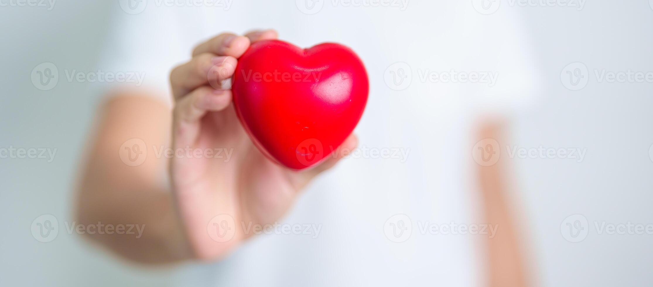 hand holding red heart shape in hospital. love, donor, world heart day, world health day, CSR donation and Insurance concepts photo