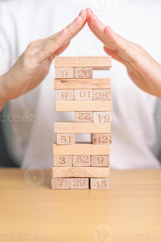 hand cover wooden block on the tower. Business planning, Risk Management, Solution, insurance and strategy Concepts photo