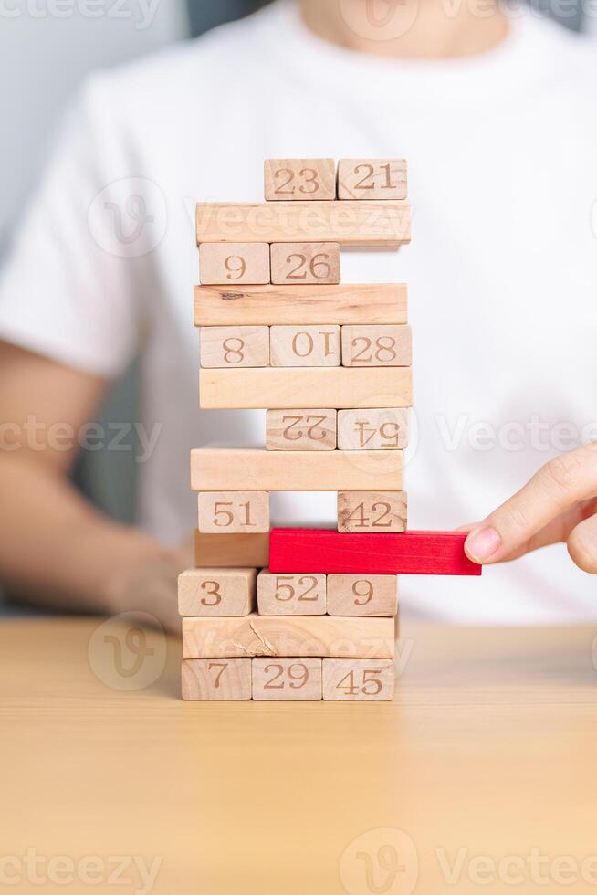 hand pulling wooden block tower on table. Business planning, Risk Management, Solution, leader, strategy, Crisis, falling Business, and Economic recession concept photo