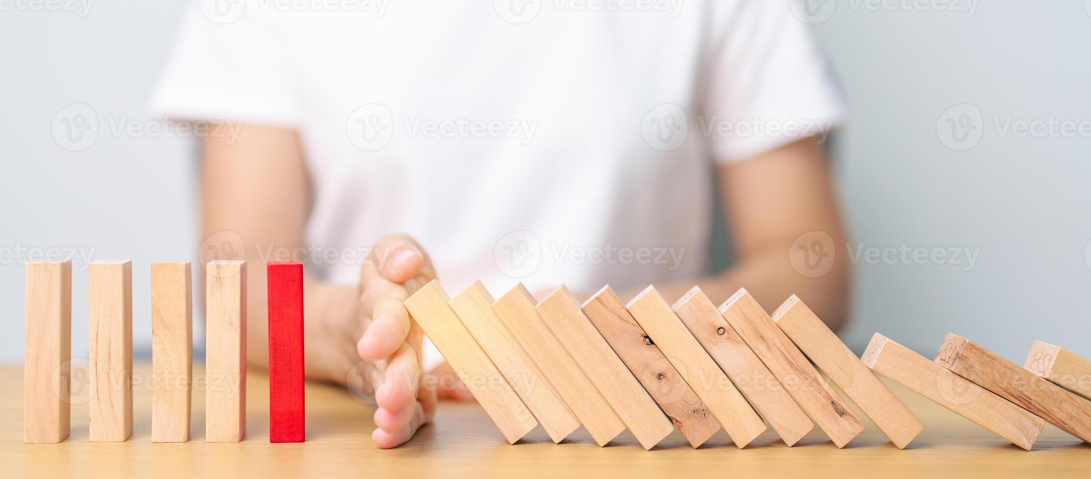 Hand stop falling wood domino blocks on table. Crisis, fall Business, Risk management, Economic recession, Strategy and solutions concept photo
